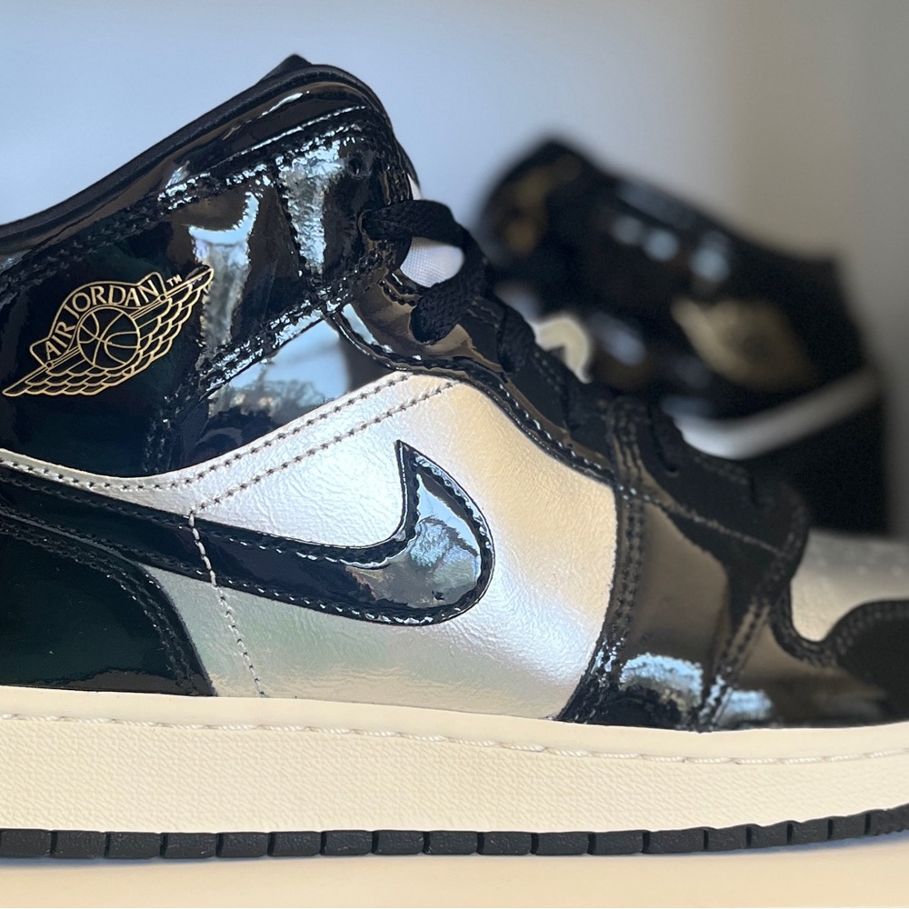Air Jordan 1 Mid SE (GS) 
Glossy Black & Silver Gold Sneakers. FZ3938 001